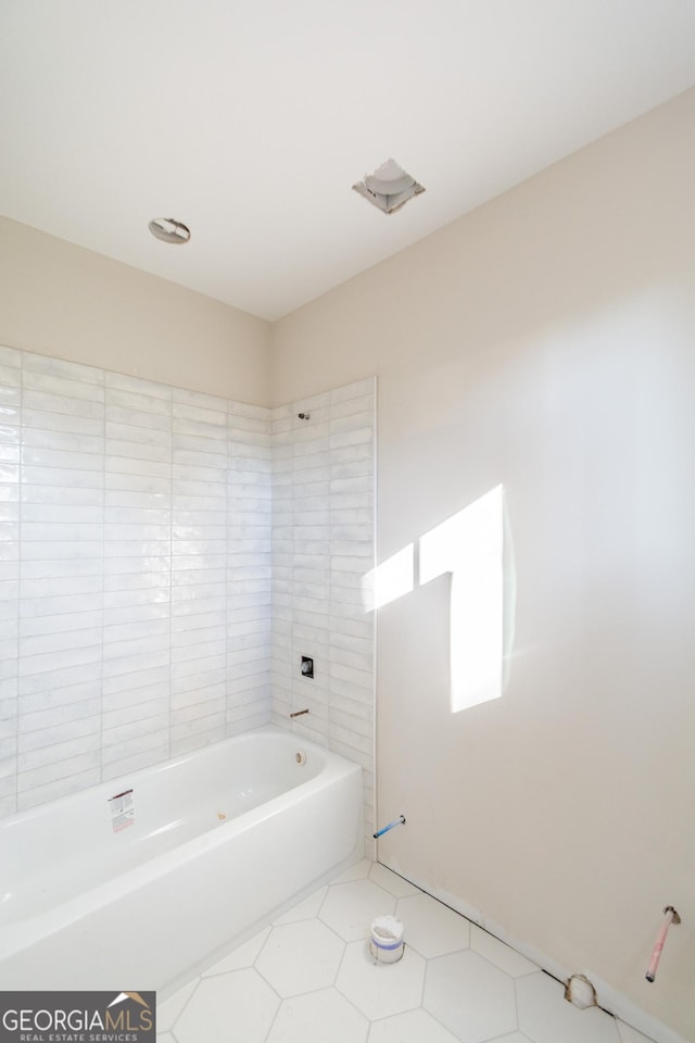 bathroom featuring tile patterned floors and tiled shower / bath