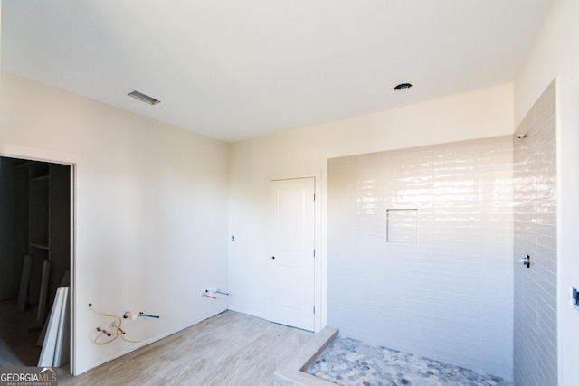 interior space with a shower and hardwood / wood-style floors