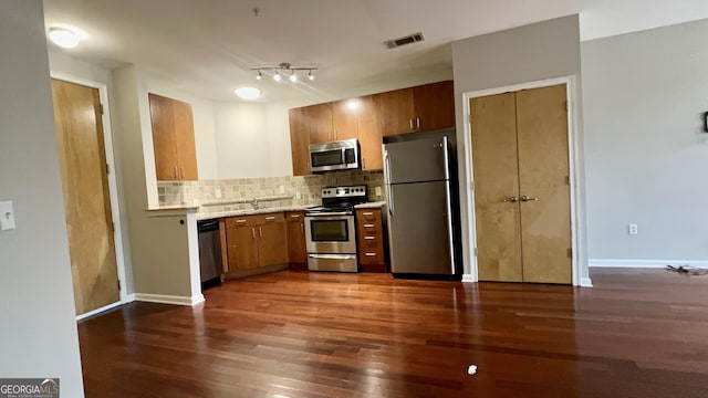 kitchen featuring dark hardwood / wood-style flooring, sink, appliances with stainless steel finishes, and tasteful backsplash