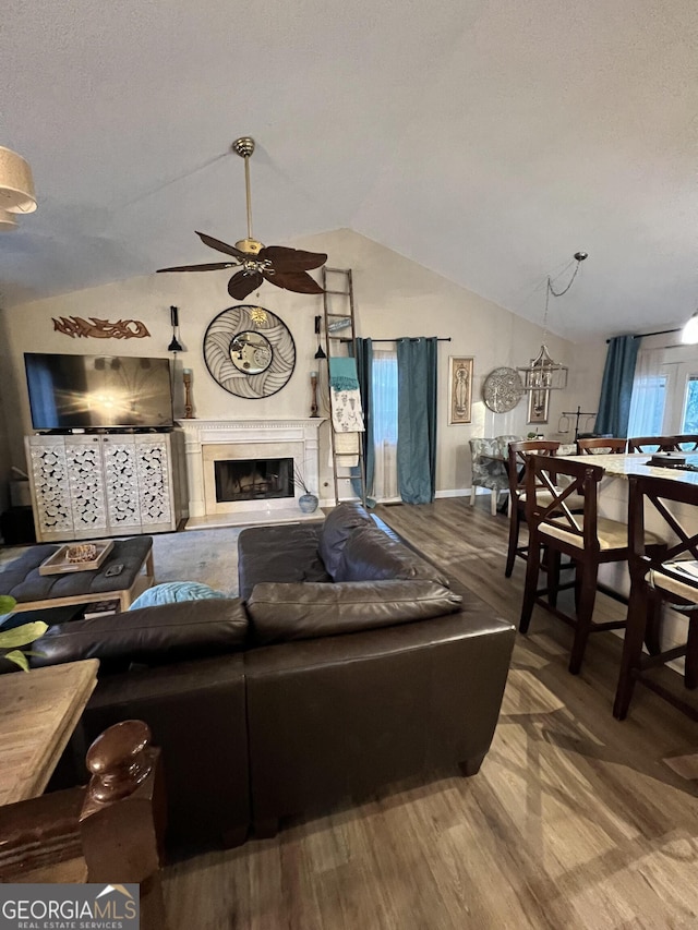 living room featuring ceiling fan, wood-type flooring, and lofted ceiling