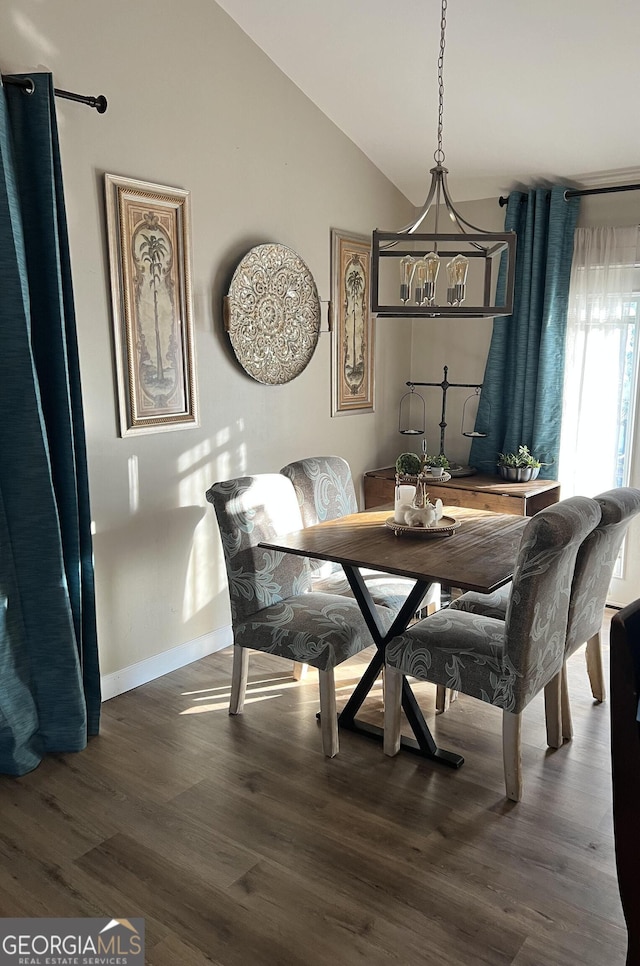 dining space with vaulted ceiling and dark hardwood / wood-style flooring