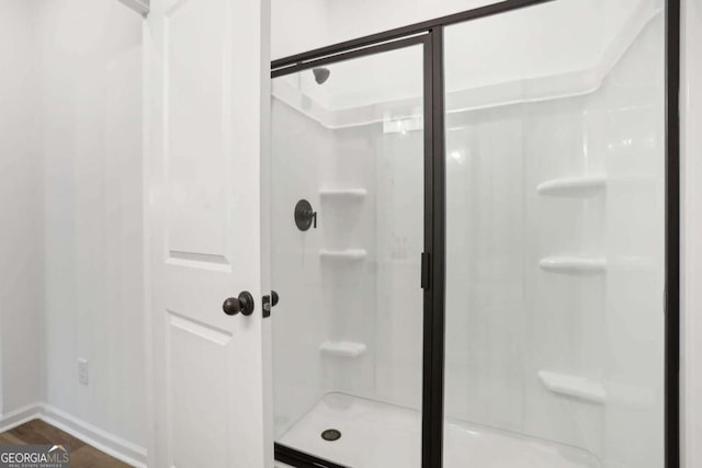 bathroom featuring hardwood / wood-style floors and an enclosed shower