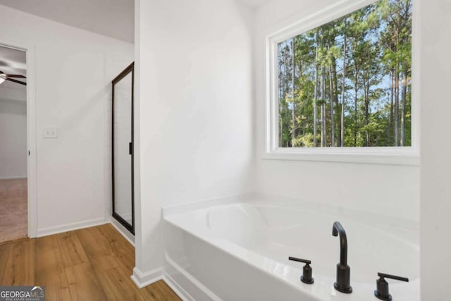 bathroom featuring wood-type flooring, separate shower and tub, plenty of natural light, and ceiling fan