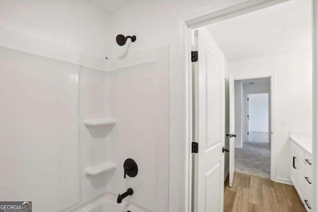 bathroom with wood-type flooring, vanity, and shower / bathtub combination