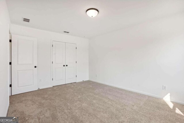 unfurnished bedroom featuring carpet flooring and a closet