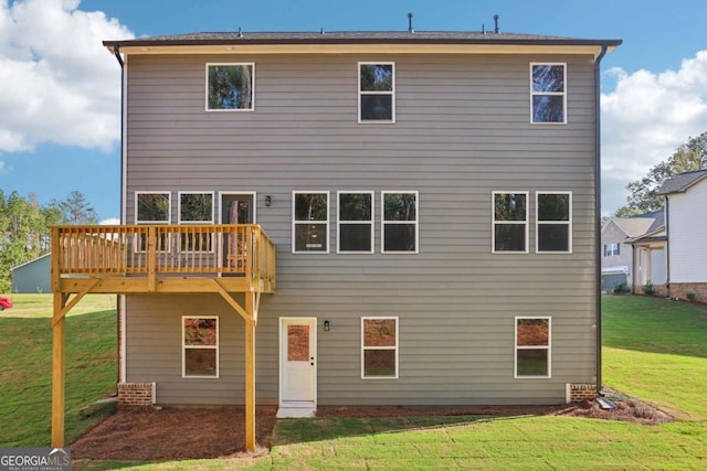 rear view of house with a yard and a wooden deck