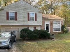 split level home with a front lawn and a garage