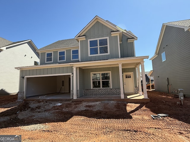 view of front of house featuring covered porch, board and batten siding, and a garage