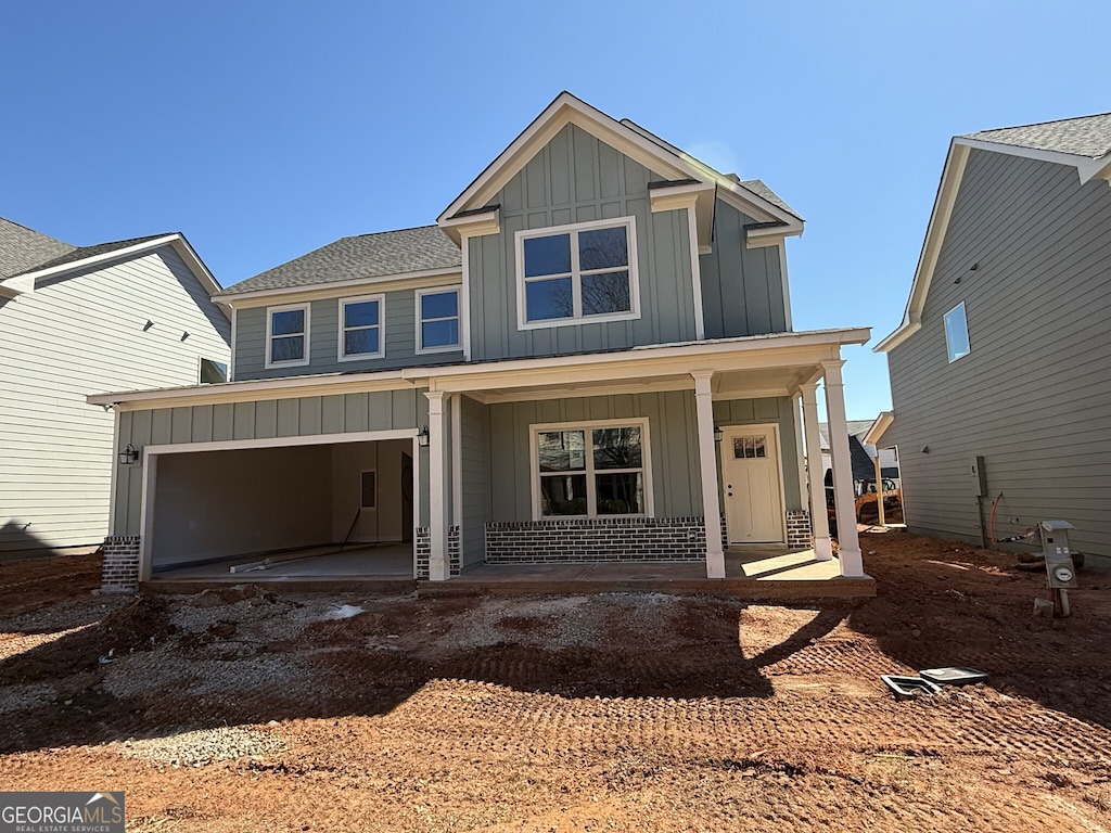 view of front of property with driveway, roof with shingles, a porch, an attached garage, and board and batten siding