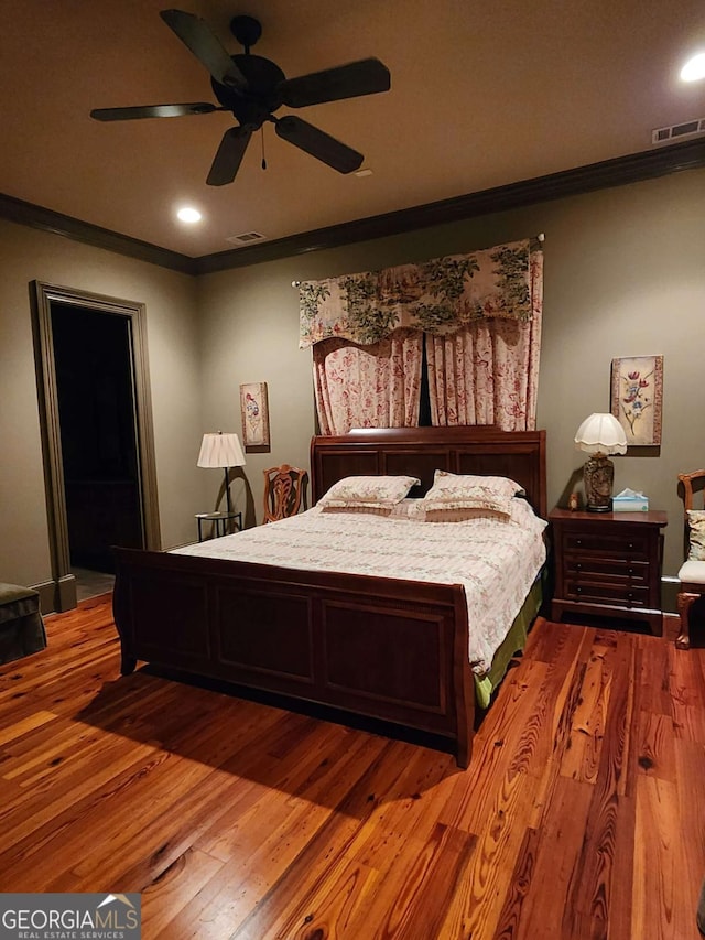 bedroom with hardwood / wood-style floors, ceiling fan, and ornamental molding