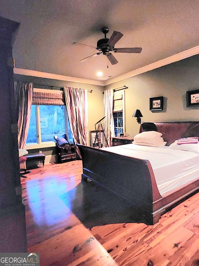 bedroom with wood-type flooring, a textured ceiling, ceiling fan, and ornamental molding