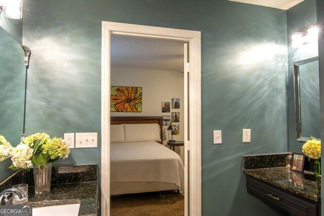 bathroom featuring hardwood / wood-style floors, vanity, and a textured ceiling