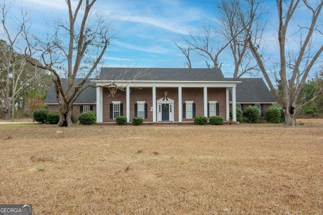 greek revival inspired property with a front lawn