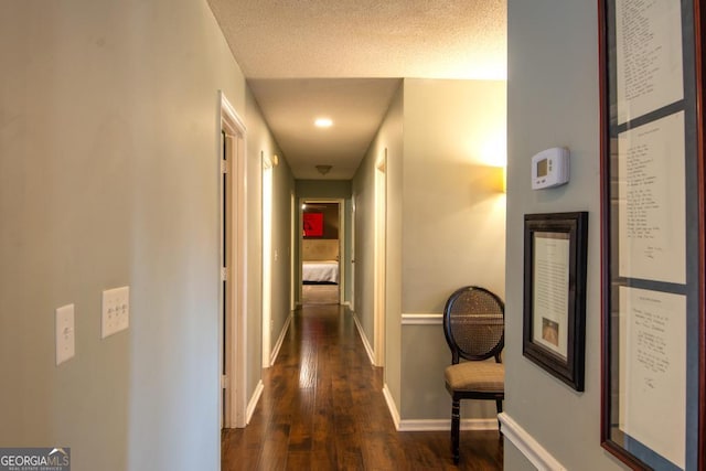 hallway featuring dark hardwood / wood-style flooring and a textured ceiling