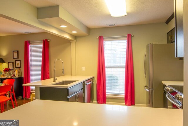 kitchen with sink, decorative backsplash, a kitchen bar, kitchen peninsula, and stainless steel appliances