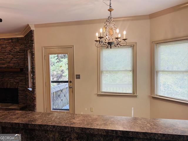 doorway with a fireplace, a notable chandelier, and ornamental molding