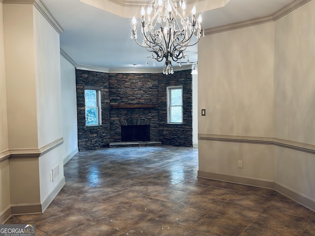 unfurnished living room featuring an inviting chandelier, a stone fireplace, a tray ceiling, and crown molding