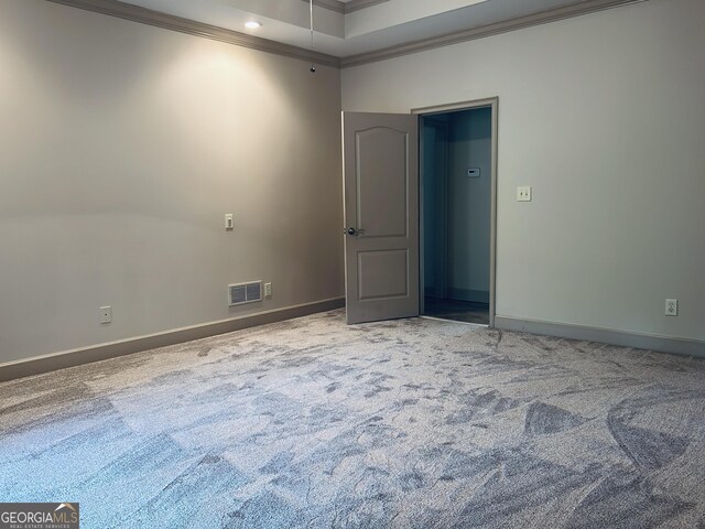 empty room featuring carpet and crown molding