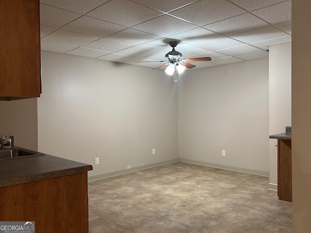 interior space featuring a paneled ceiling, ceiling fan, and sink