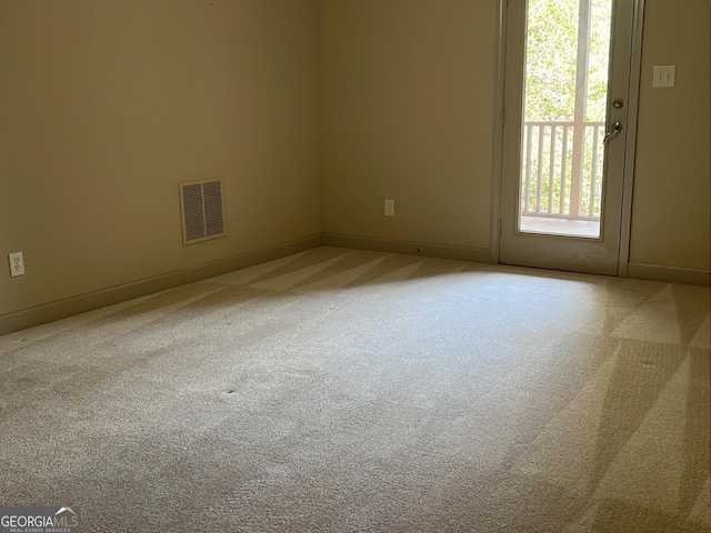 spare room featuring light carpet