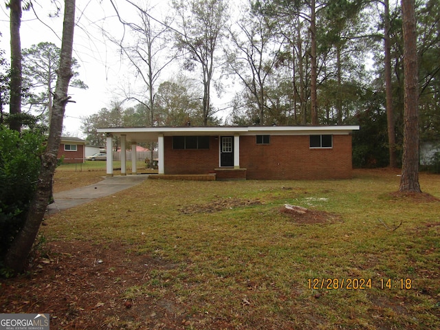 rear view of house featuring a yard and a carport