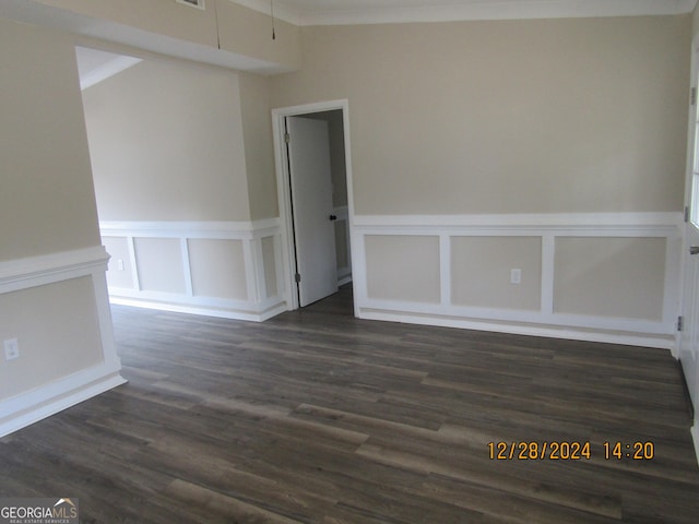 empty room featuring dark hardwood / wood-style floors and crown molding