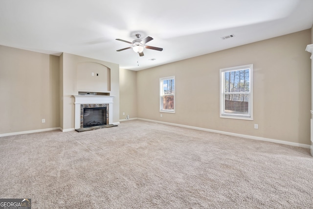 unfurnished living room with ceiling fan, light colored carpet, and plenty of natural light