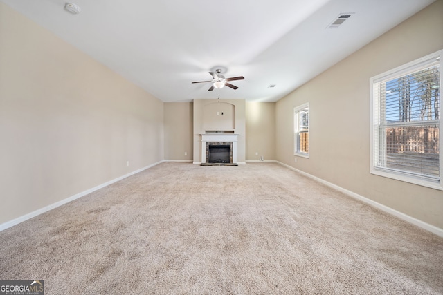 unfurnished living room with light colored carpet and ceiling fan