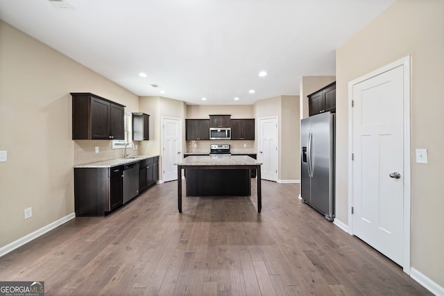 kitchen featuring sink, dark brown cabinets, a center island, and appliances with stainless steel finishes