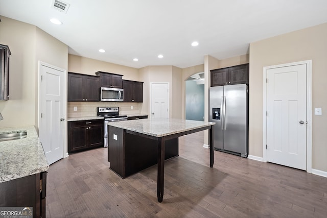 kitchen featuring sink, backsplash, a kitchen bar, a kitchen island, and stainless steel appliances