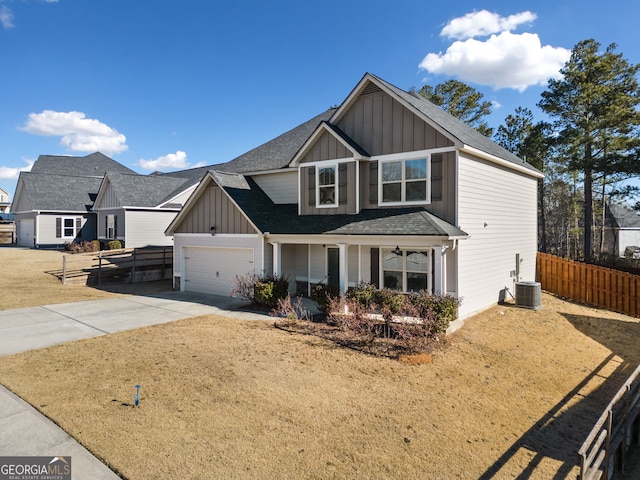 view of front of property with a garage, central AC, and a front lawn