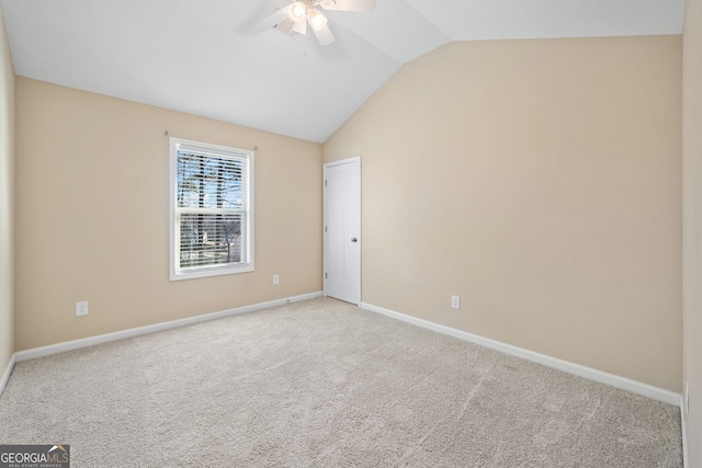 empty room featuring light colored carpet, vaulted ceiling, and ceiling fan