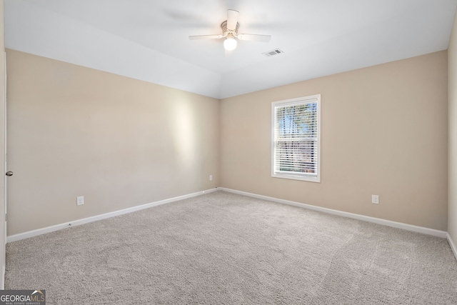 spare room featuring carpet floors, ceiling fan, and vaulted ceiling