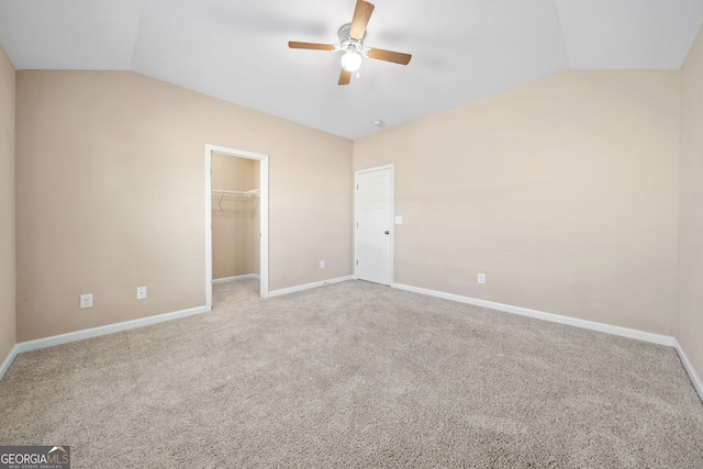 carpeted empty room with ceiling fan and vaulted ceiling