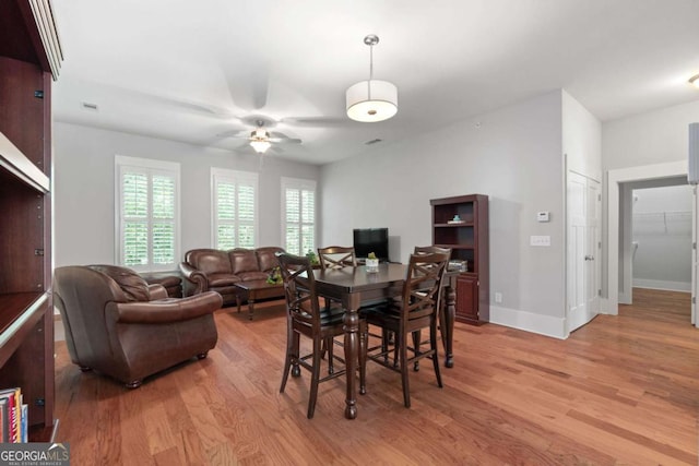 dining area with light hardwood / wood-style flooring and ceiling fan