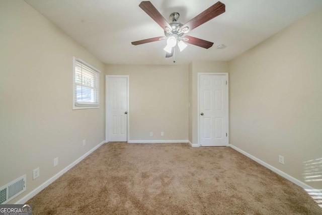 carpeted spare room featuring ceiling fan