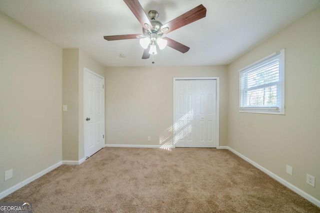 unfurnished bedroom featuring ceiling fan, a closet, and light carpet