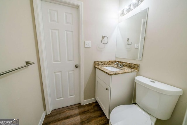 bathroom with vanity, toilet, and wood-type flooring