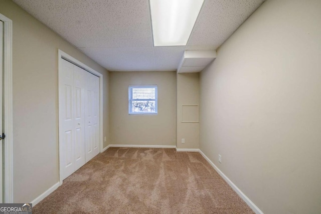 unfurnished bedroom featuring light carpet and a closet