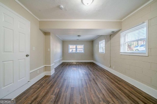 spare room featuring dark hardwood / wood-style flooring, ornamental molding, and a textured ceiling