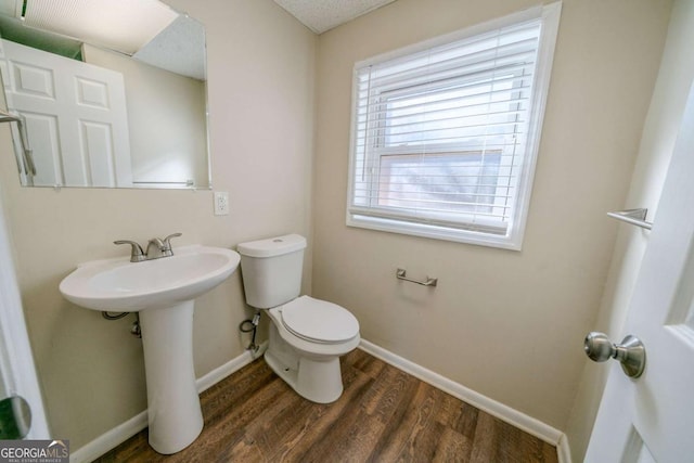 bathroom with hardwood / wood-style floors and toilet