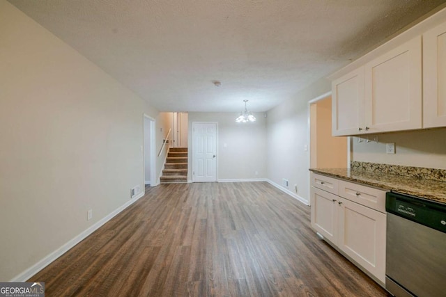 kitchen featuring pendant lighting, white cabinets, stainless steel dishwasher, dark hardwood / wood-style floors, and light stone countertops