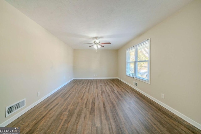 spare room featuring a textured ceiling, ceiling fan, and dark hardwood / wood-style floors