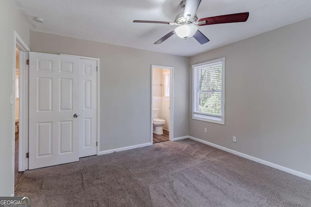 unfurnished bedroom with carpet, ensuite bathroom, ceiling fan, a textured ceiling, and a closet