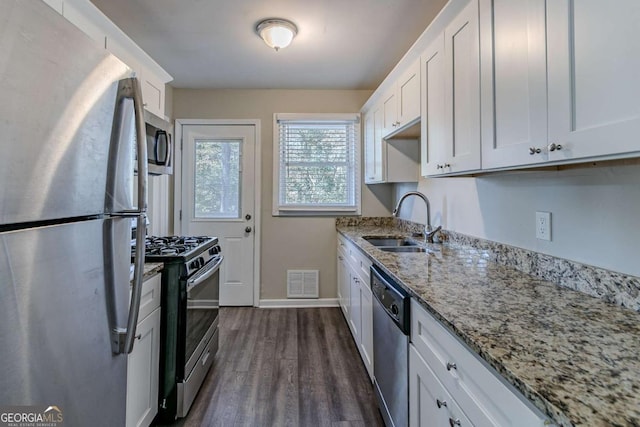 kitchen featuring sink, light stone counters, dark hardwood / wood-style flooring, white cabinetry, and stainless steel appliances