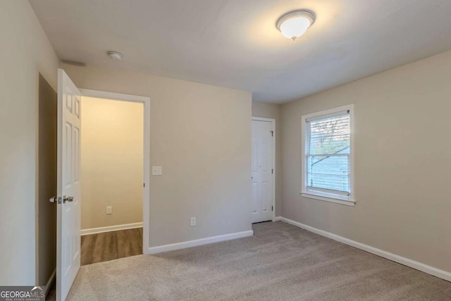 unfurnished bedroom featuring light carpet