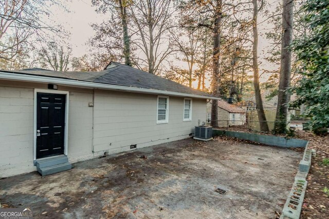 back house at dusk featuring cooling unit