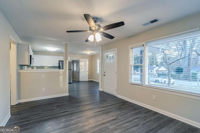 unfurnished living room featuring dark hardwood / wood-style flooring and ceiling fan