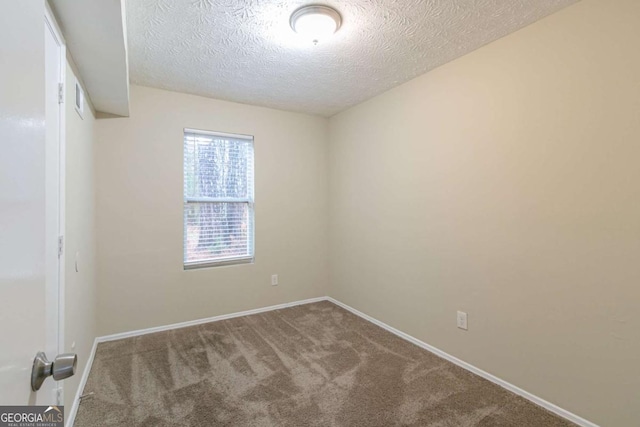 empty room featuring a textured ceiling and carpet floors