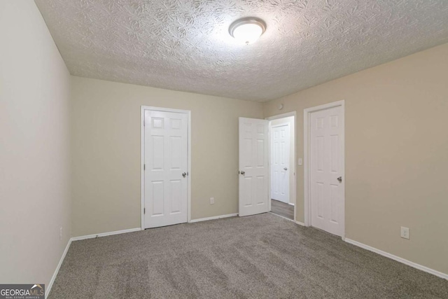 unfurnished bedroom featuring a textured ceiling and carpet floors